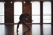 Ballerina performing ballet dance move in ballet studio — Stock Photo