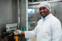 Portrait of confident male worker operating machine in juice factory — Stock Photo