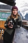 Mujer en ropa de invierno sosteniendo vaso de cerveza - foto de stock