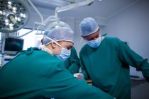 Group of surgeons performing operation in operation theater of hospital — Stock Photo