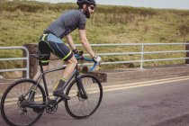 Atleta montar bicicleta deportiva en la carretera del país - foto de stock