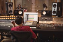 Audio engineer working on sound mixer in recording studio — Stock Photo