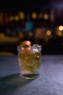 Крупный план апельсинового коктейля в стакане у стойки в баре — стоковое фото