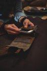 Ремесленница готовит кожаный чехол для мобильного телефона в мастерской — стоковое фото