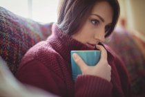 Schöne Frau mit einer Kaffeetasse zu Hause — Stockfoto