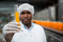 Close up of male worker checking juice in factory — Stock Photo