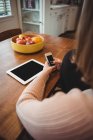 Frau nutzt Handy und digitales Tablet zu Hause — Stockfoto