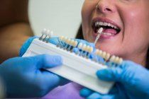 Dentista esaminando paziente femminile con paralumi dentali presso la clinica dentale — Foto stock