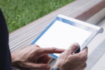 Cropped image of businessman using digital tablet outside office building — Stock Photo