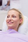 Bionda paziente femminile sorridente in clinica — Foto stock