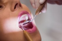 Gros plan du dentiste examinant les dents des patientes — Photo de stock