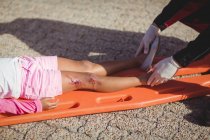 Paramedics putting injured girl onto a backboard on street — Stock Photo