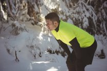 Müder Mann macht im Winter Pause beim Joggen — Stockfoto