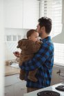 Vater hält Baby in der Küche zu Hause — Stockfoto