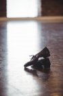 Pair of dancing shoes on wooden floor in dance studio — Stock Photo