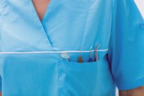 Серединний відділ стоматолога, що носить зубні інструменти в кишені в стоматологічній клініці — стокове фото