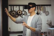 Uomo che sperimenta la realtà virtuale auricolare in cucina a casa — Foto stock