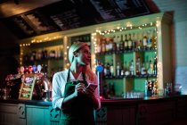 Улыбающаяся официантка записывает заказ в баре — стоковое фото