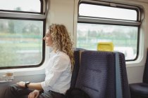 Side view of businesswoman looking through window while travelling — Stock Photo