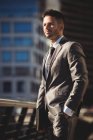 Бизнесмен с дневником стоит на офисной террасе при дневном свете — стоковое фото