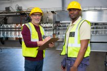 Portrait of male workers standing in juice factory — Stock Photo
