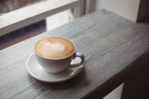 Close-up of cup of coffee on wooden table — Stock Photo