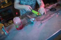 Бармен різання полуниці для приготування коктейлю за лічильником в барі — стокове фото