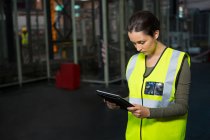 Confident female worker using tablet pc in warehouse — Stock Photo