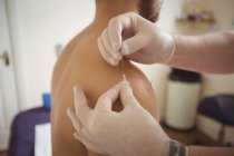Fisioterapeuta realizando agulhas secas no ombro do paciente na clínica — Fotografia de Stock