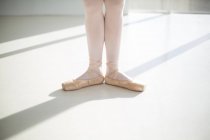 Section basse des pieds de danseur de ballet exécutant la danse de ballet dans le studio de ballet — Photo de stock