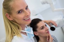 Dentista levando dentes de paciente do sexo feminino raio-x na clínica — Fotografia de Stock