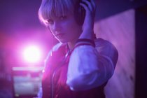 Porträt eines weiblichen DJs, der in einer Bar über Kopfhörer Musik hört — Stockfoto