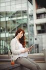 Беременная деловая женщина, использующая цифровой планшет в офисных помещениях — стоковое фото