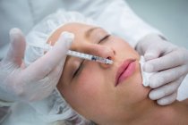 Крупним планом жіночий пацієнт отримує ін'єкції ботокса на губах — стокове фото