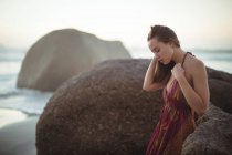 Schöne Frau steht an einem sonnigen Tag am Strand — Stockfoto