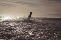 Silhouette eines Mannes, der in der Abenddämmerung im Meerwasser surft — Stockfoto