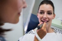 Молода жінка має стоматологічний огляд в клініці — стокове фото