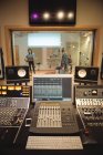 Mixer audio in uno studio di registrazione con musicisti in sottofondo — Foto stock