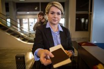 Donna d'affari consegna la carta d'imbarco al banco del terminal dell'aeroporto — Foto stock