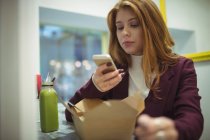 Frau fotografiert Salat mit Handy im Restaurant — Stockfoto