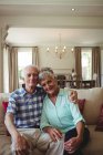 Porträt eines Senioren-Paares, das es sich auf dem Sofa im heimischen Wohnzimmer gemütlich macht — Stockfoto