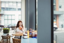 Donna d'affari incinta che ha succo di frutta in mensa ufficio — Foto stock