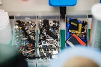 Крупный план различных электронных компонентов в пластиковых коробках — стоковое фото