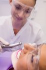 Dentiste examinant une patiente en clinique — Photo de stock