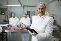 Portrait of smiling butcher using digital tablet — Stock Photo