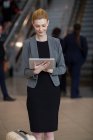 Femme d'affaires utilisant une tablette numérique à l'aéroport — Photo de stock