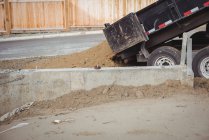 Close-up of dumper unloading mud at construction site — Stock Photo