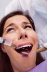 Dentist injecting anesthetics in scared female patient mouth in clinic — Stock Photo