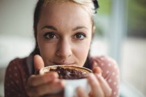 Крупним планом усміхнена жінка має чашку кави в кафе — стокове фото