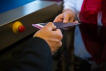 Mitarbeiterinnen geben dem Geschäftsmann am Check-in-Schalter die Bordkarte — Stockfoto